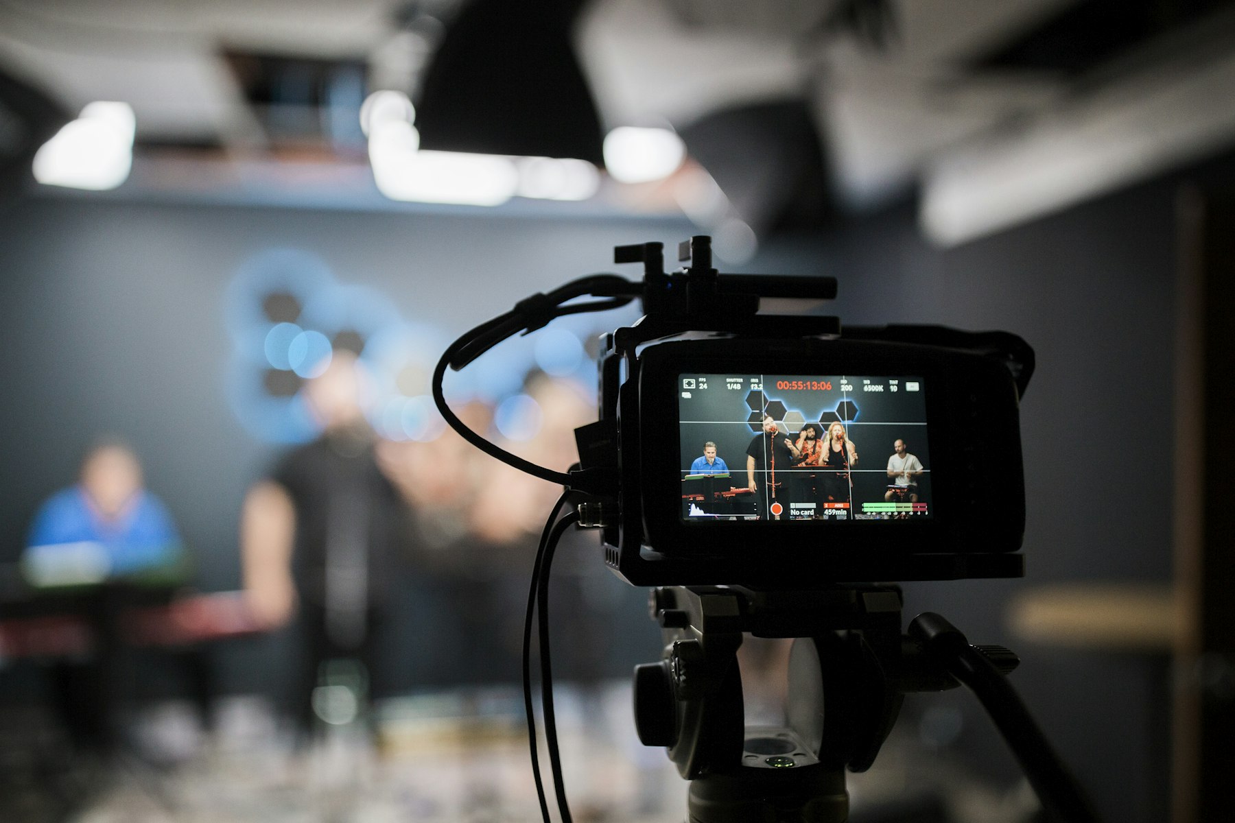A video camera recording a presenter in a studio