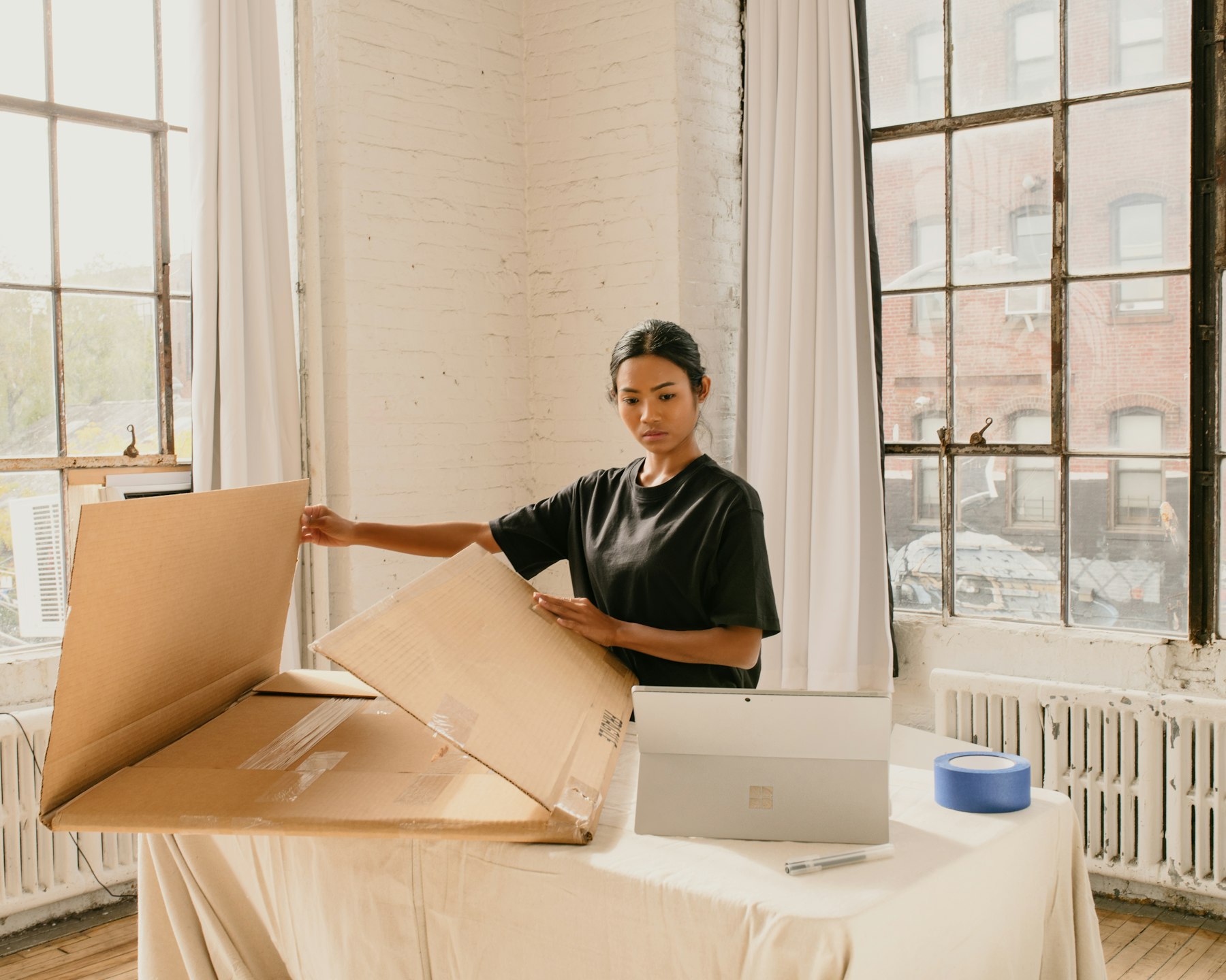A small-business owner packing an order at her workspace